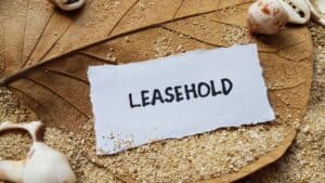 Leasehold property concept with sandy background and seashells.