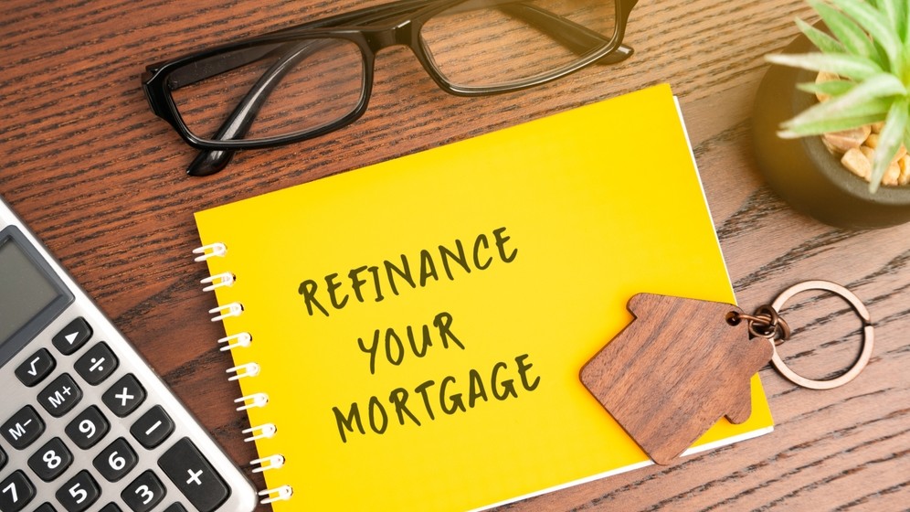 Refinance your mortgage concept. Process of obtaining a new loan to replace an existing home loan, often to secure better terms. Real estate and finance. Notebook, house and calculator on table