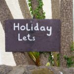 Holiday Lets sign, on tree advertising property to be rented. Air BnB and rentals are causing a housing crisis in many countries as locals and young people cannot get on the housing market.