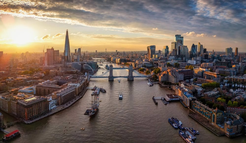 Panoramic aerial view of the skyline of London, England, with Tower Bridge, River Thames and City skyscrapers during a colorful sunset