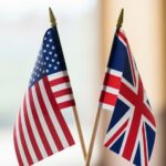 Close-up of elegant miniature USA and UK flags side by side, symbol of alliance, diplomacy, partnership and strong international relations, premium look