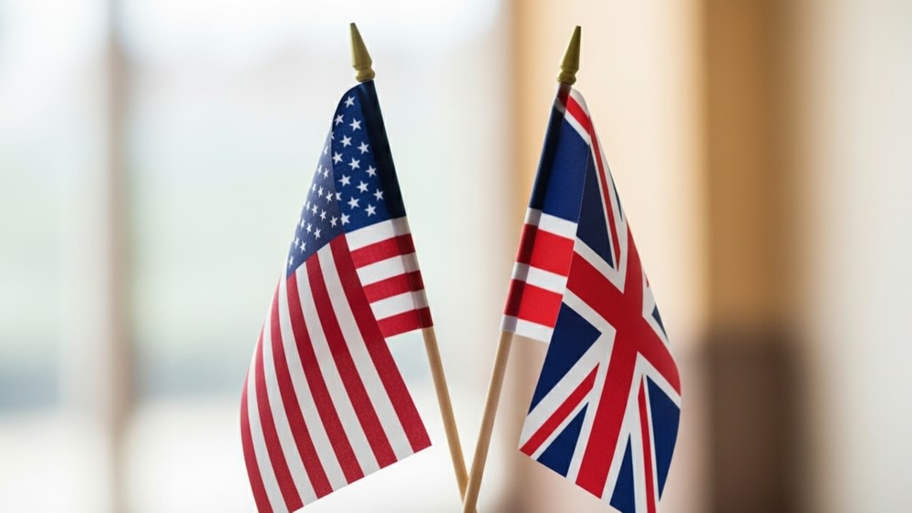 Close-up of elegant miniature USA and UK flags side by side, symbol of alliance, diplomacy, partnership and strong international relations, premium look