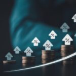 Stacked coins with rising percent house icons and upward arrow symbolizing higher interest rates mortgage costs inflation and smart investment growth in digital finance era