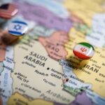 Political map of the Middle East with flag pins of USA, Israel, and Iran on key geographic locations, representing international relations and geopolitical alliance concept and war in middle east. High quality photo