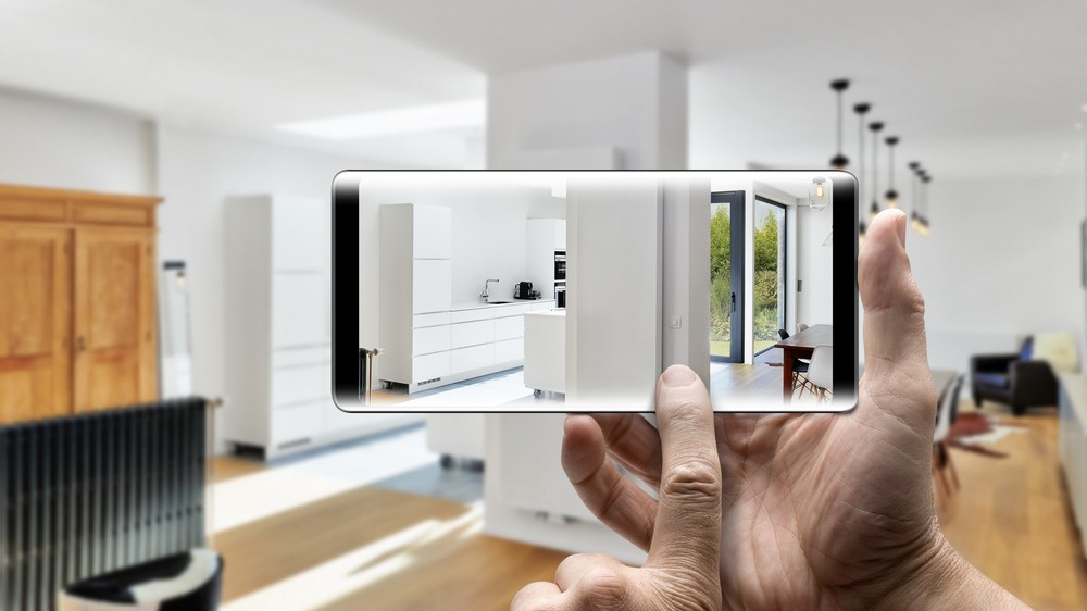 Two hands holding a mobile Smartphone and take a picture in a Modern luxury living room and kitchen